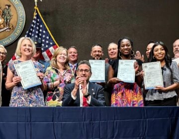 Delaware state lawmakers holding signed ICE bills